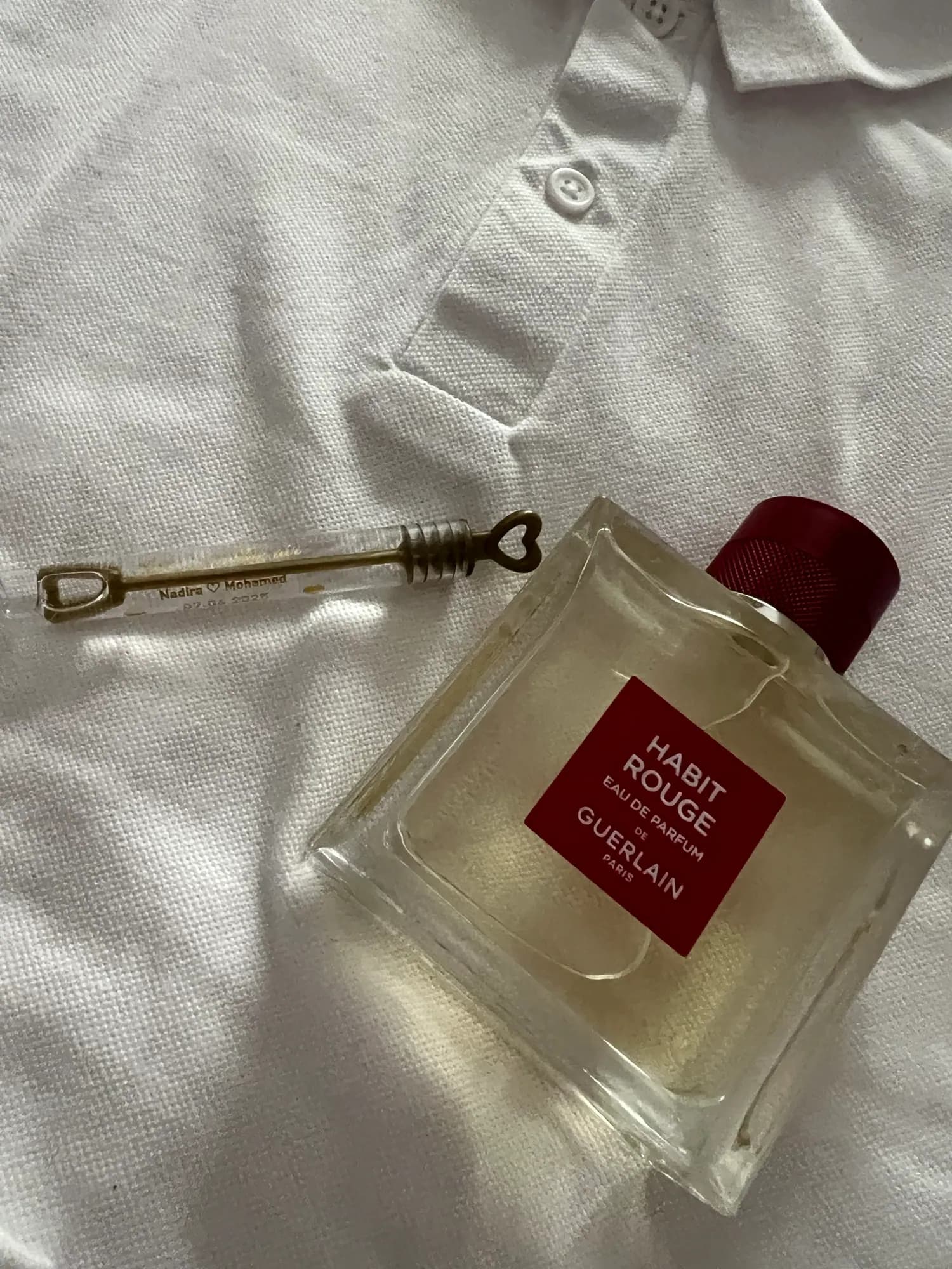 Parfum et clé ancienne sur du linge blanc