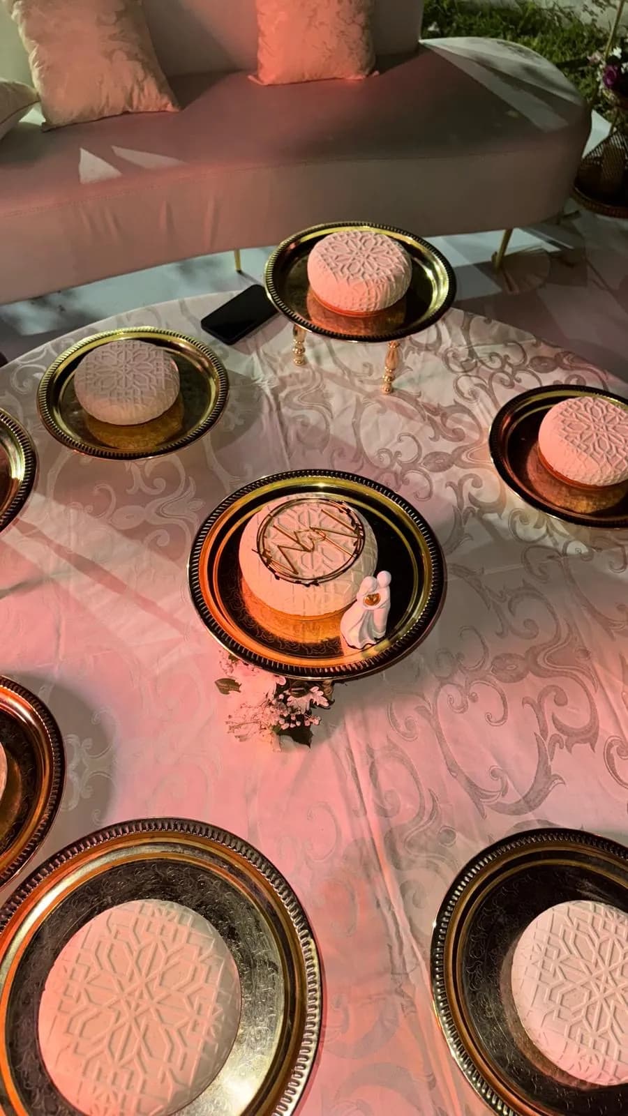 Petits gâteaux roses sur plateaux dorés