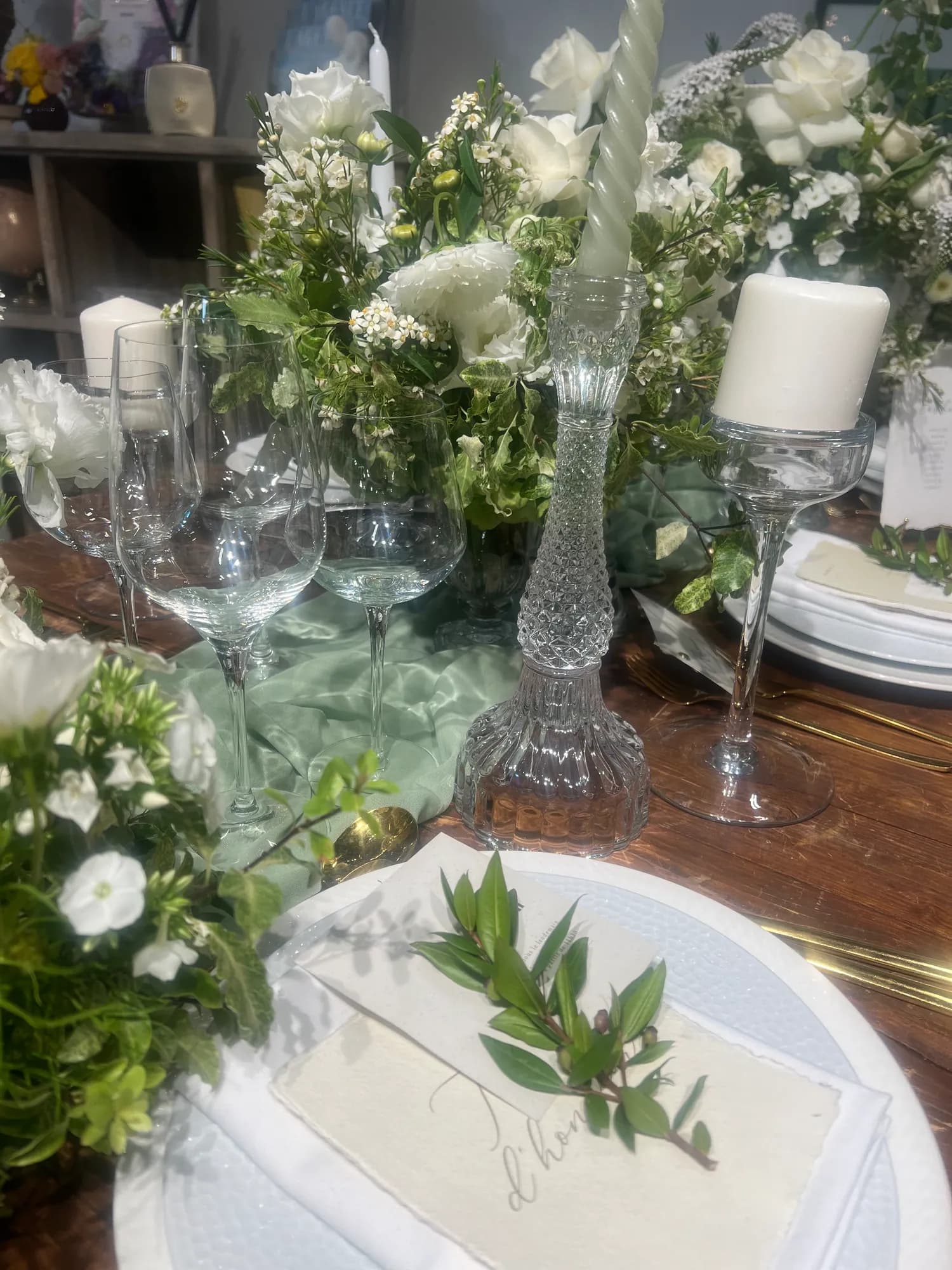 Table aux fleurs blanches et chemin de table vert sauge
